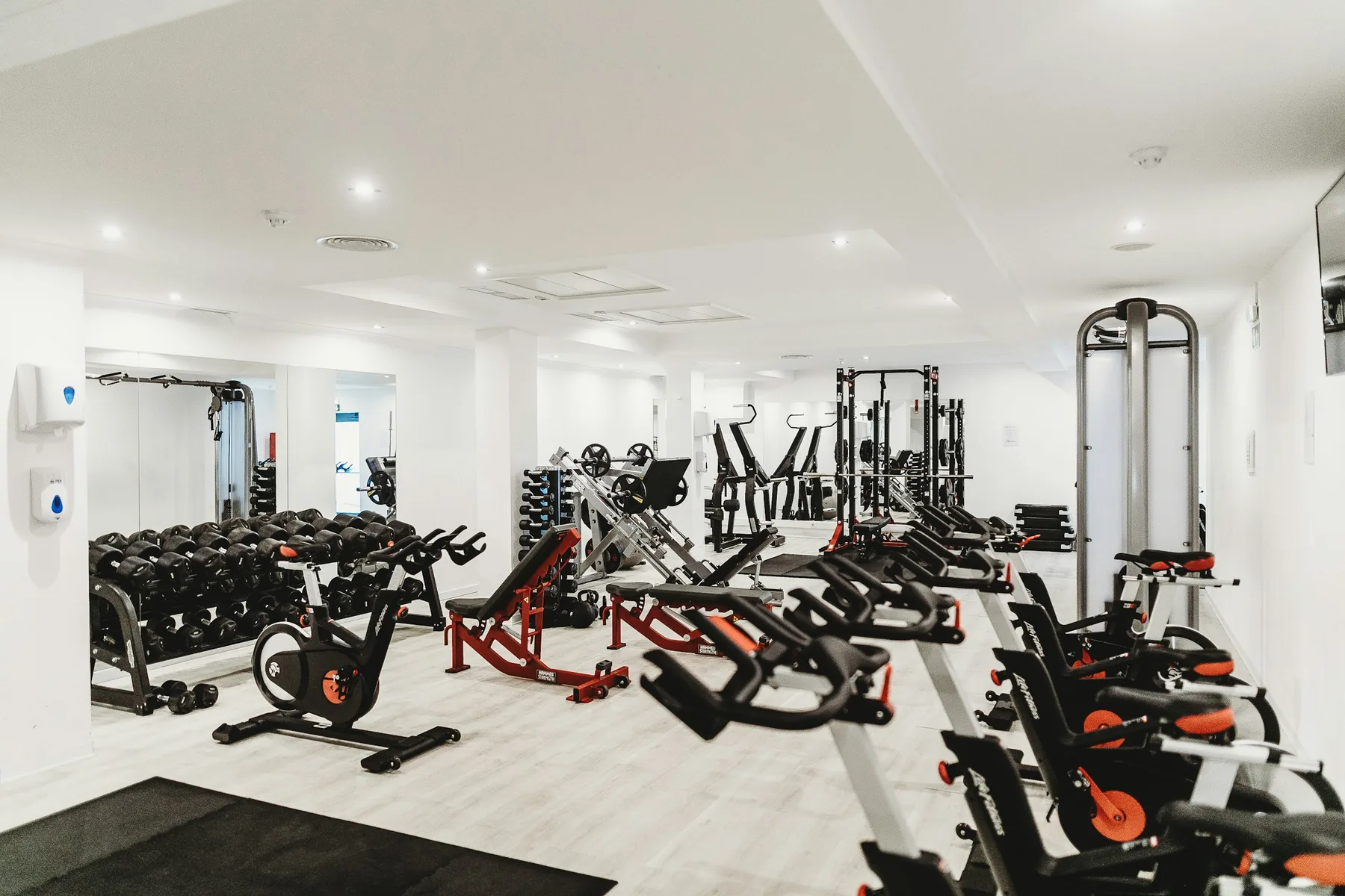 A dark cycling studio with rows of bikes ready for a class